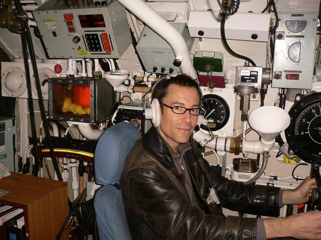 Andrew Smith sitting at a flight console with lots of buttons and levers.