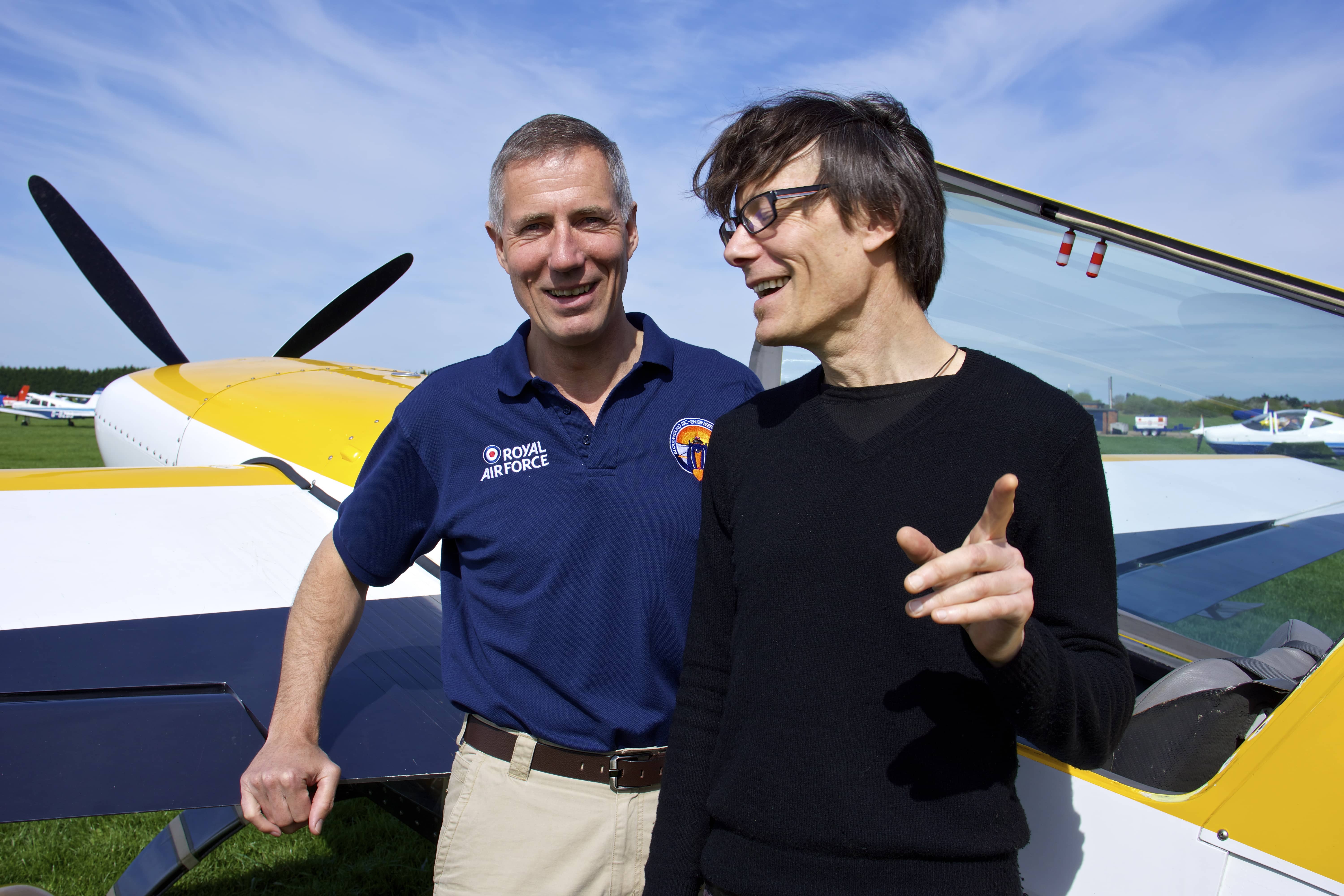 Andrew standing windswept in front of planes in a field.